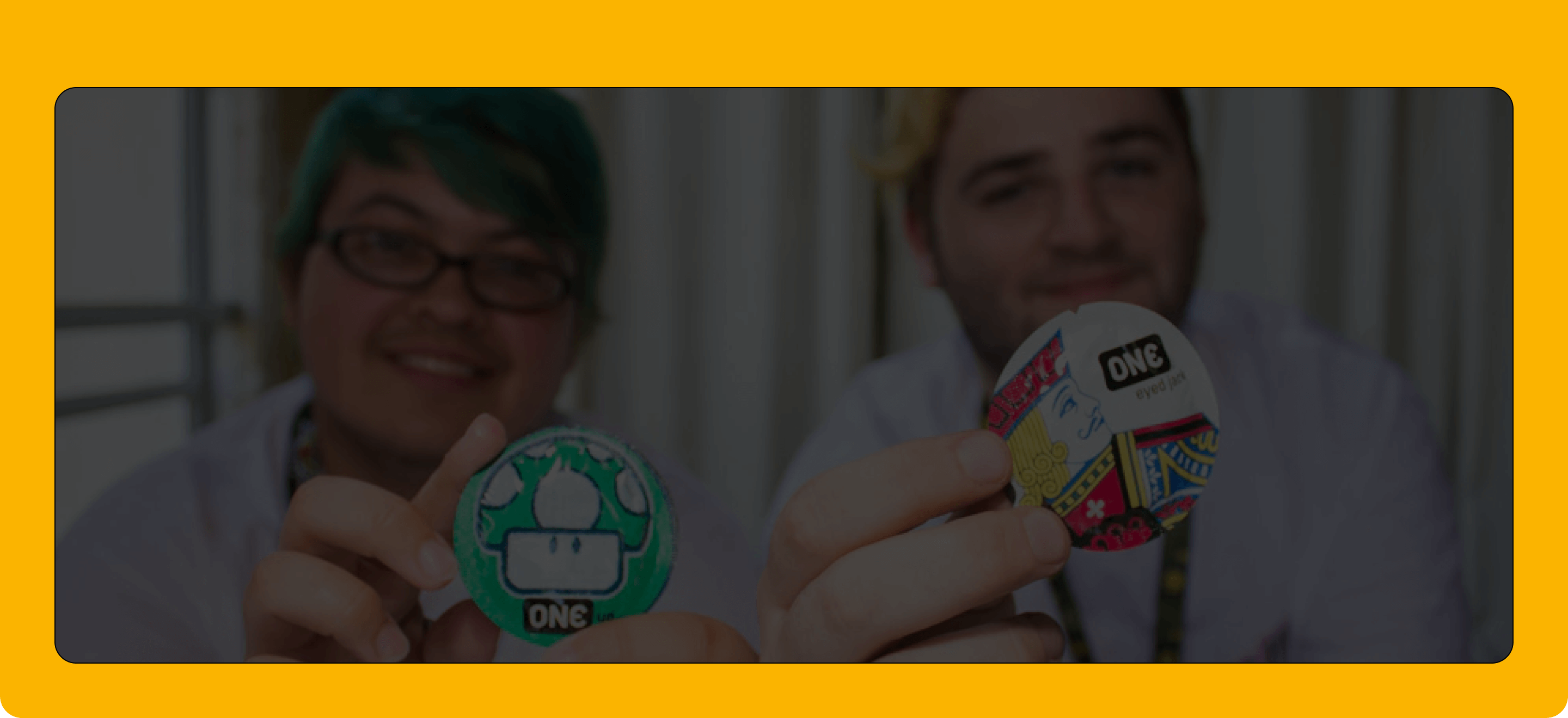 Two people holding colorful buttons with visible branding against a blurred background.