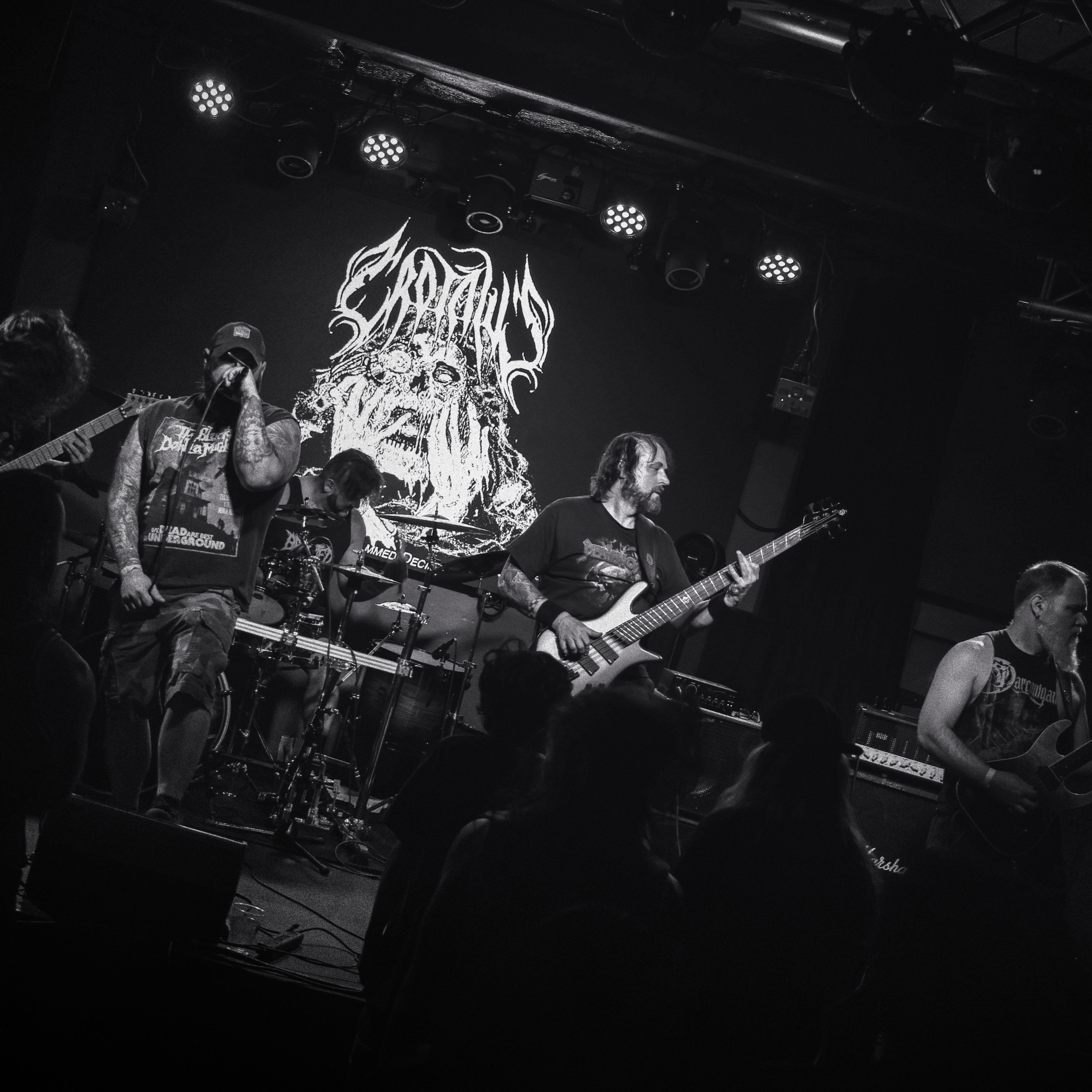 Band performing on stage with a large logo in the background
